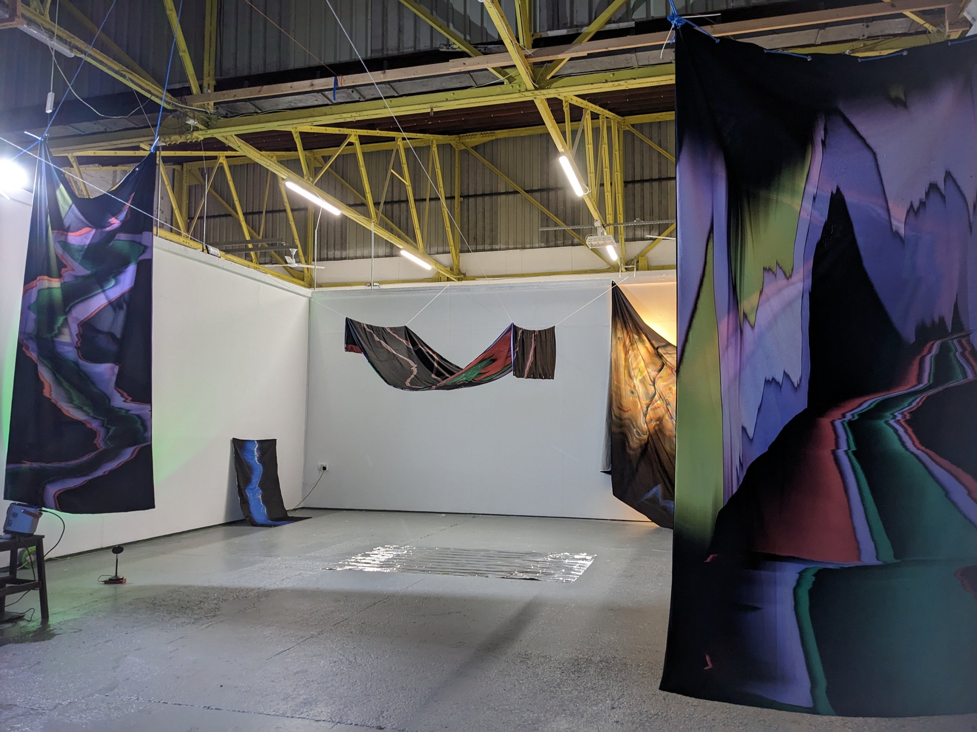 Shiny Corridor exhibition with large fabric textiles pieces hanging from the roof